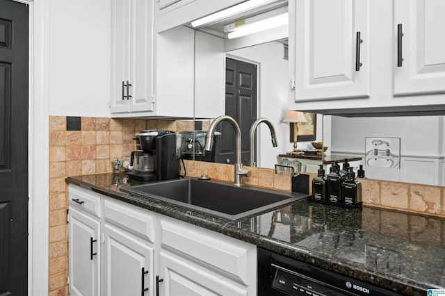 kitchen with dishwasher, white cabinetry, sink, and dark stone countertops