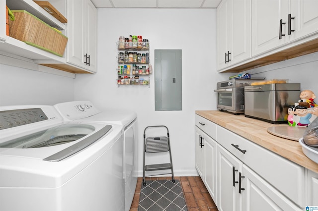 clothes washing area with cabinets, electric panel, and washer and clothes dryer