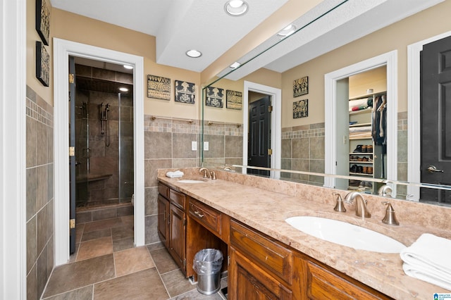 bathroom featuring tile walls, vanity, and a shower with shower door