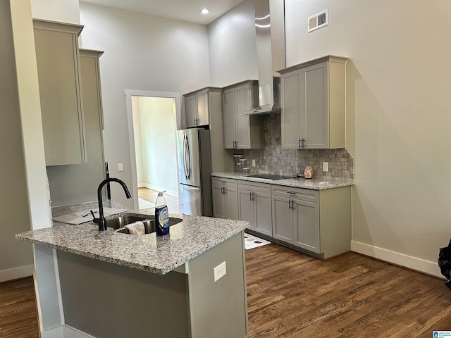 kitchen featuring sink, stainless steel fridge, kitchen peninsula, and black electric stovetop