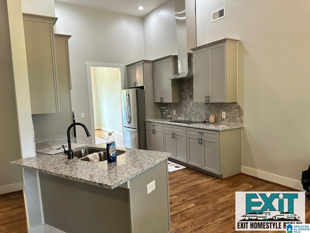 kitchen with sink, black electric cooktop, stainless steel fridge, gray cabinets, and kitchen peninsula