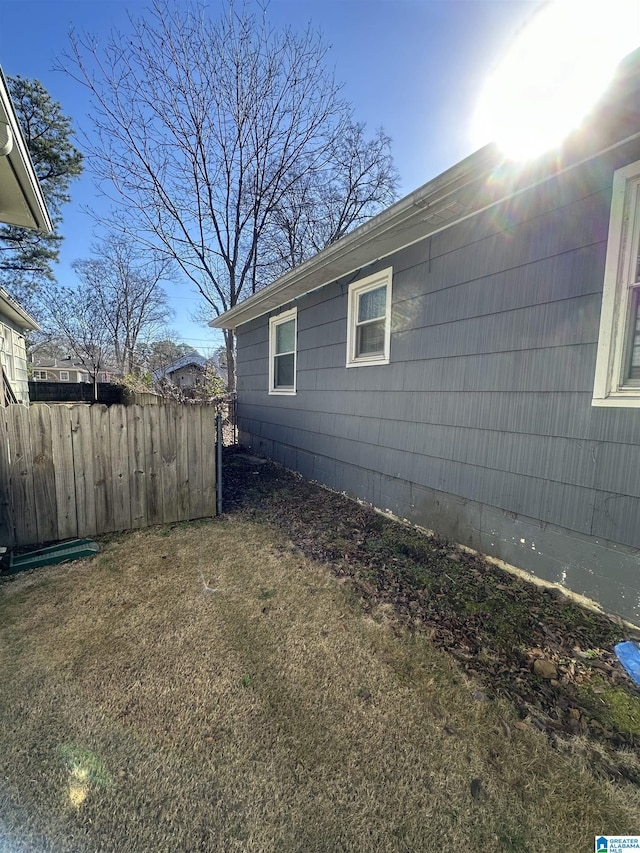 view of side of home with a yard