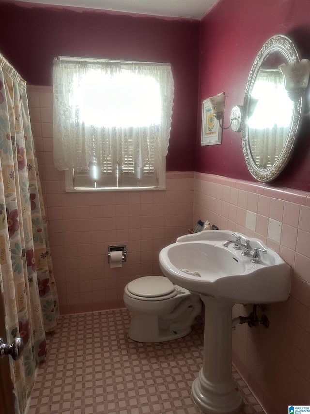 bathroom featuring tile walls, a shower with curtain, and toilet