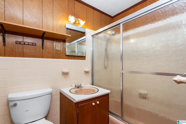 full bathroom with toilet, wood walls, shower / bath combination with glass door, ornamental molding, and vanity