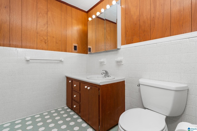 bathroom featuring vanity, tile walls, and toilet