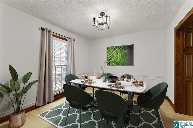 dining room with light hardwood / wood-style flooring and a textured ceiling