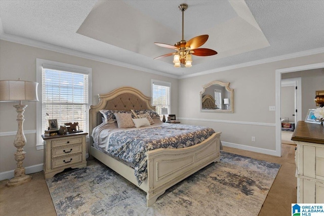 carpeted bedroom with crown molding, ceiling fan, a tray ceiling, and a textured ceiling