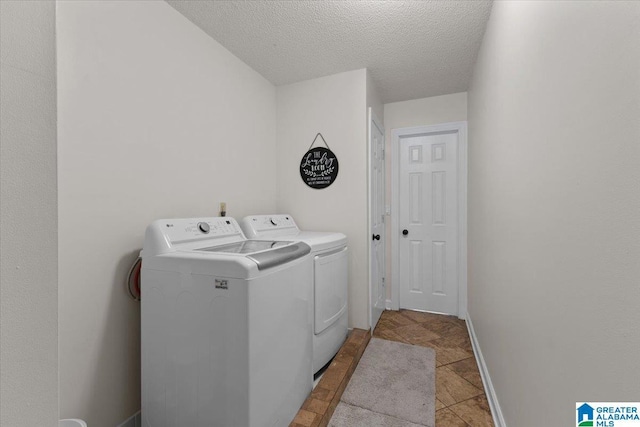 laundry area with washer and dryer and a textured ceiling