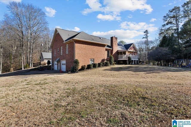 view of side of property with a garage and a lawn