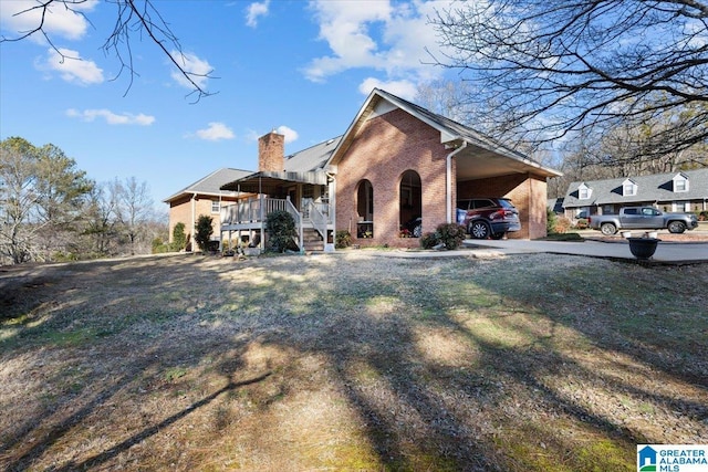 view of front of property with a front yard, a carport, and covered porch