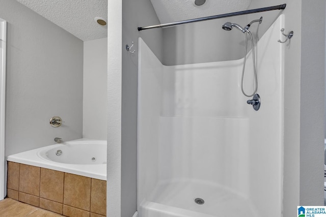 bathroom featuring tile patterned flooring, plus walk in shower, and a textured ceiling