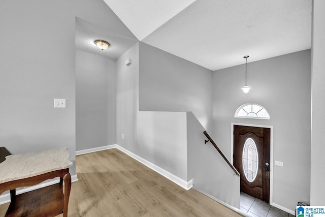 foyer with a textured ceiling and light hardwood / wood-style flooring