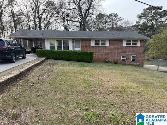 single story home featuring a front yard and a carport