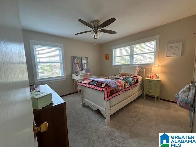 carpeted bedroom with multiple windows and ceiling fan