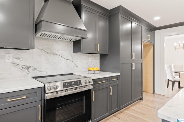 kitchen with premium range hood, stainless steel electric range, and gray cabinetry