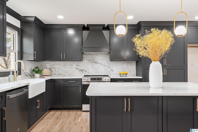 kitchen featuring sink, appliances with stainless steel finishes, hanging light fixtures, tasteful backsplash, and custom range hood