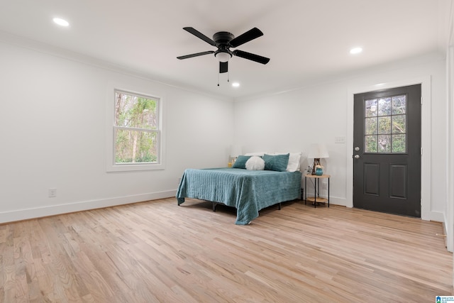 bedroom featuring multiple windows, crown molding, and light hardwood / wood-style flooring