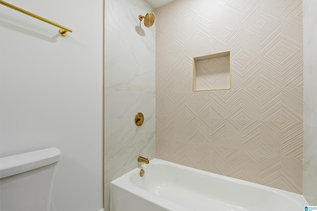 bathroom featuring tiled shower / bath and toilet