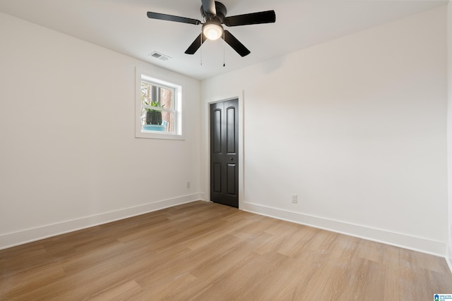 empty room with ceiling fan and light hardwood / wood-style flooring