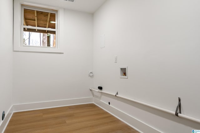 clothes washing area with gas dryer hookup, hookup for a washing machine, and light hardwood / wood-style flooring