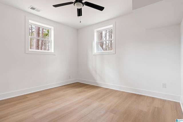 spare room with ceiling fan, plenty of natural light, and light wood-type flooring