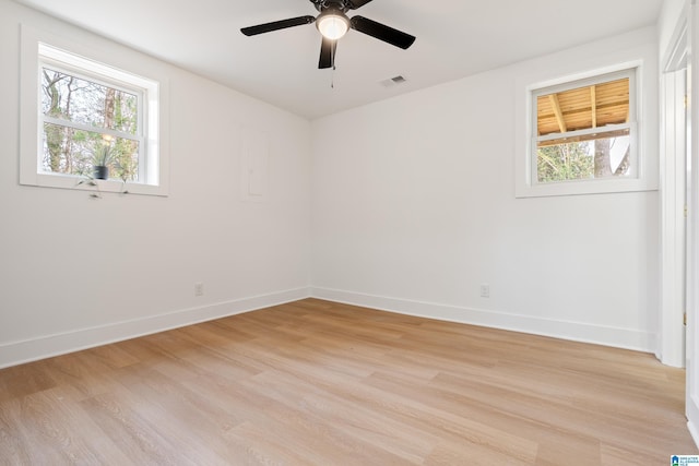 unfurnished room featuring a wealth of natural light, ceiling fan, and light wood-type flooring