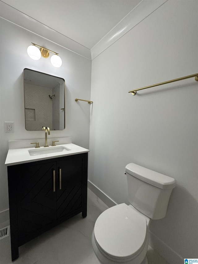 bathroom with ornamental molding, vanity, and toilet