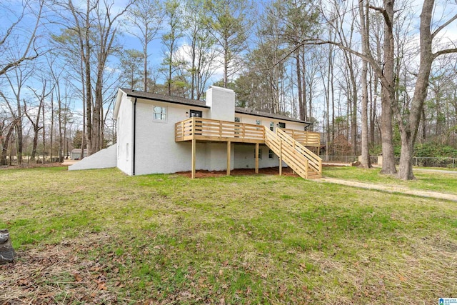 back of property featuring a deck and a lawn