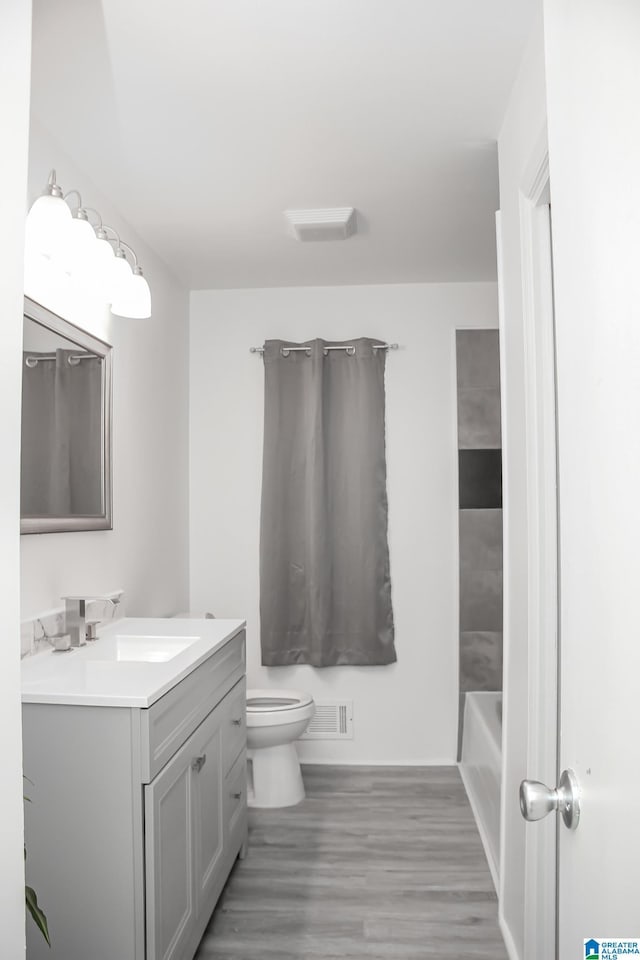 bathroom featuring vanity, hardwood / wood-style floors, and toilet