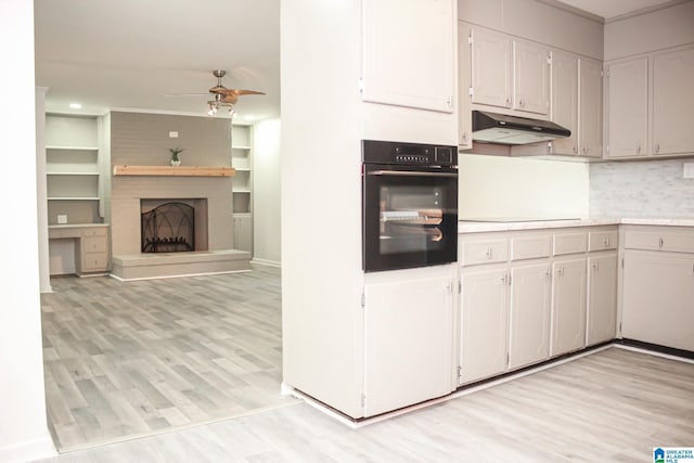 kitchen featuring white cabinetry, black appliances, light hardwood / wood-style flooring, ceiling fan, and backsplash