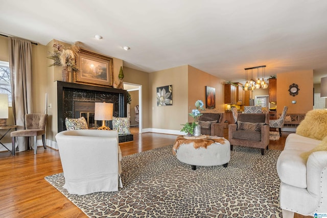 living room featuring dark hardwood / wood-style flooring, a chandelier, and a fireplace