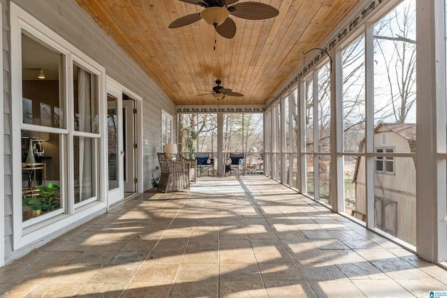 unfurnished sunroom with wooden ceiling and ceiling fan