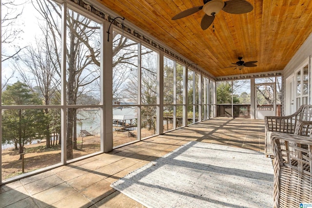 unfurnished sunroom with wood ceiling and ceiling fan