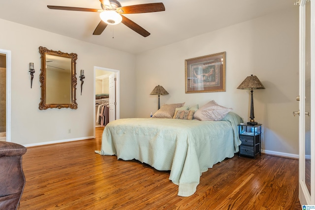 bedroom with a closet, dark wood-type flooring, ceiling fan, and a spacious closet