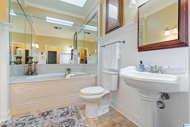 bathroom featuring a skylight, ornamental molding, toilet, and a bathing tub