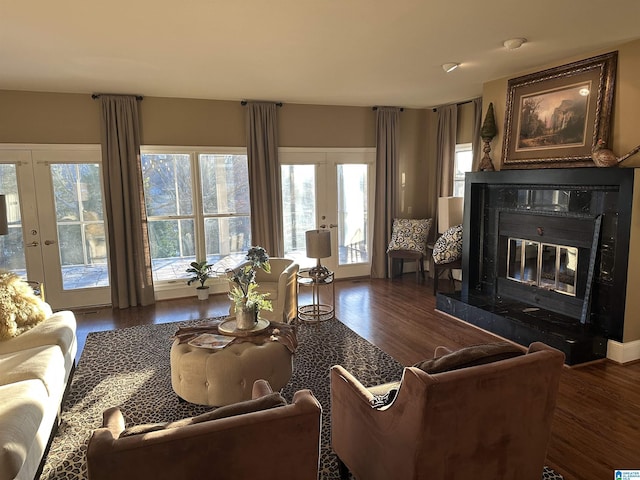 living room with a premium fireplace, dark hardwood / wood-style floors, and french doors