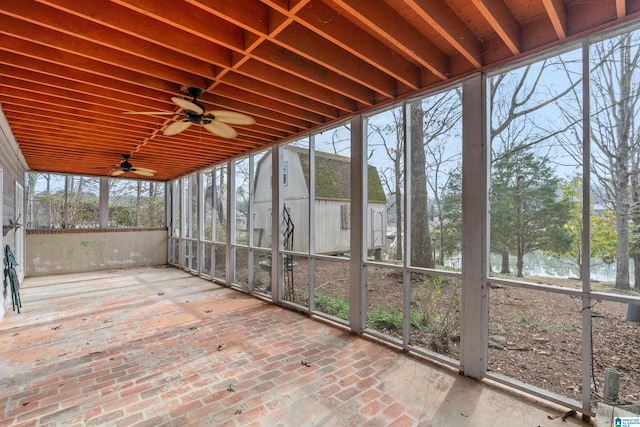 unfurnished sunroom featuring a water view and ceiling fan