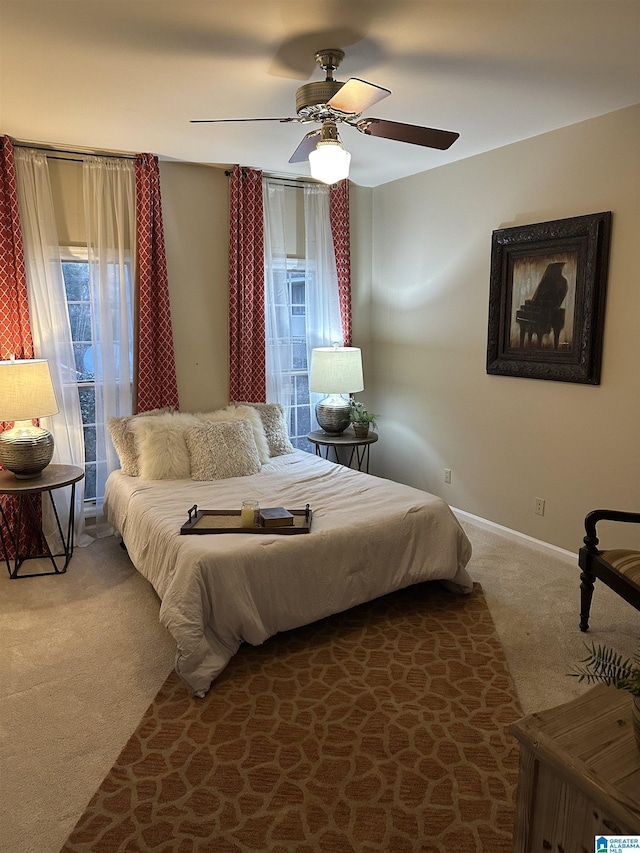 carpeted bedroom with multiple windows and ceiling fan