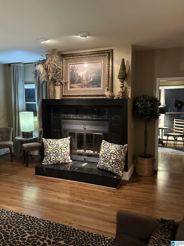 sitting room with a fireplace and wood-type flooring