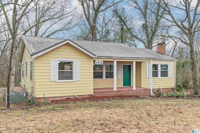 bungalow-style home featuring a porch, cooling unit, and a front yard