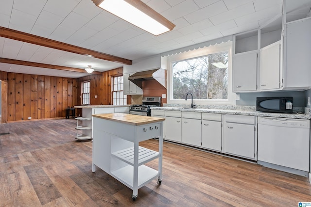 kitchen with beamed ceiling, dishwasher, white cabinets, hardwood / wood-style flooring, and stainless steel gas range