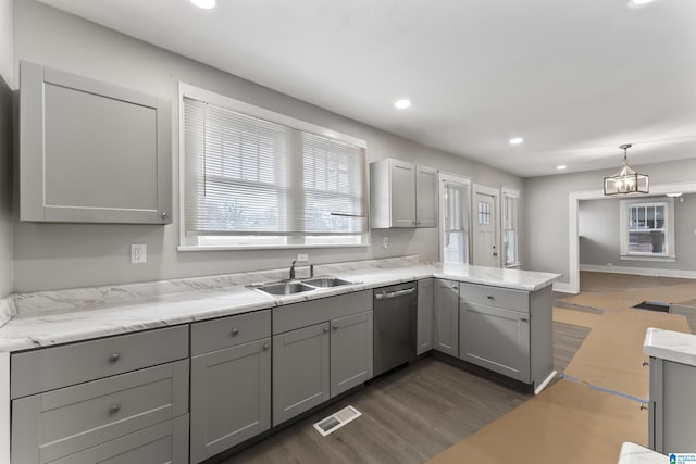 kitchen with pendant lighting, stainless steel dishwasher, sink, and gray cabinetry