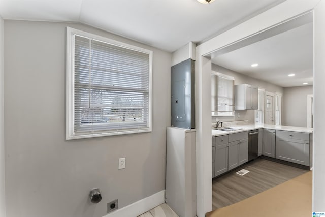 kitchen with stainless steel dishwasher, sink, gray cabinets, and light hardwood / wood-style floors