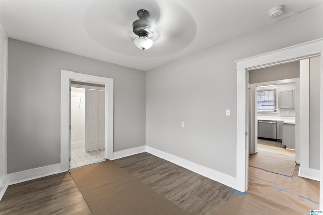 unfurnished bedroom featuring hardwood / wood-style flooring, ceiling fan, and connected bathroom