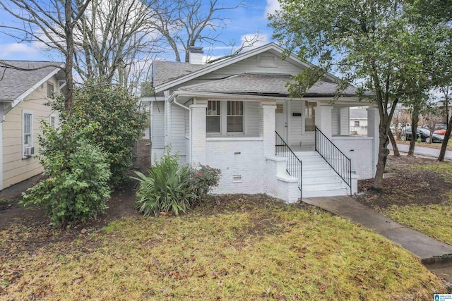 bungalow featuring a front yard and cooling unit