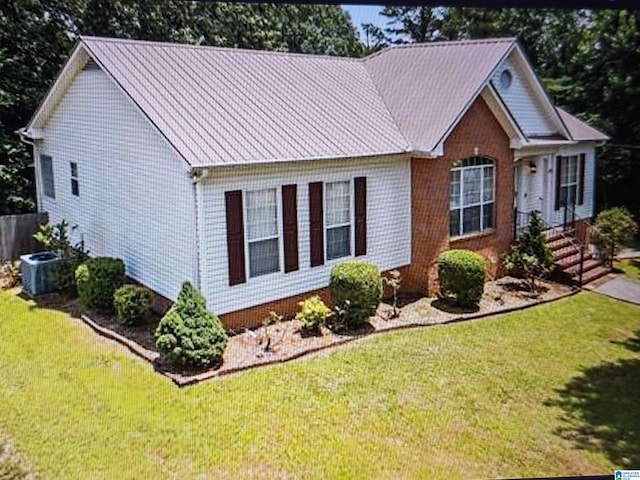 view of front of home featuring central AC unit and a front lawn