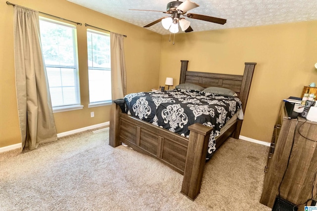 carpeted bedroom with ceiling fan and a textured ceiling