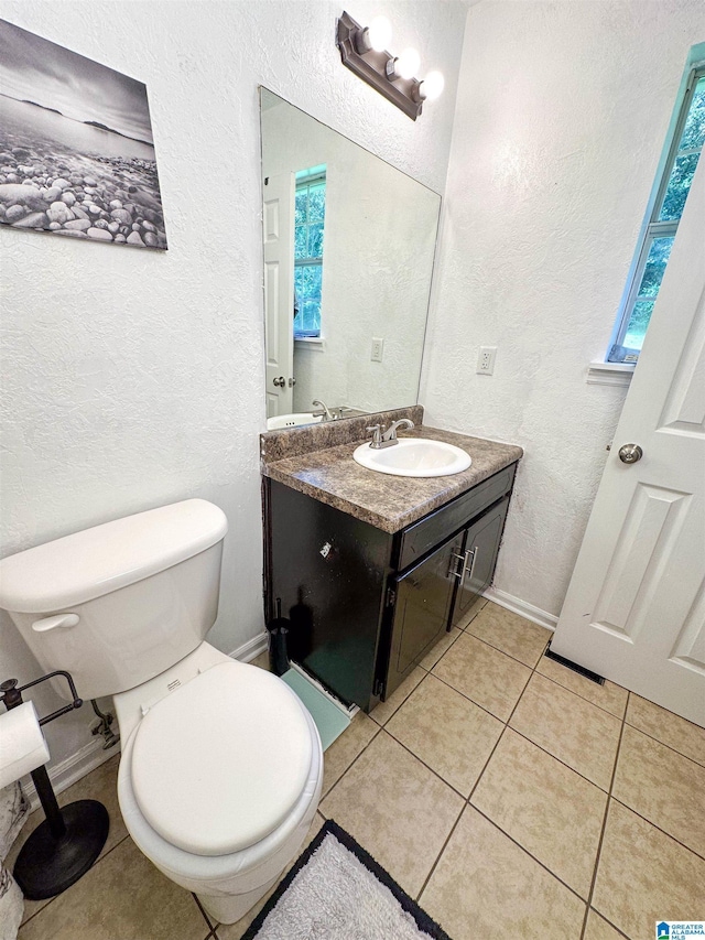 bathroom featuring vanity, toilet, and tile patterned flooring