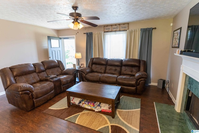 living room featuring dark hardwood / wood-style flooring, a wealth of natural light, a fireplace, and ceiling fan