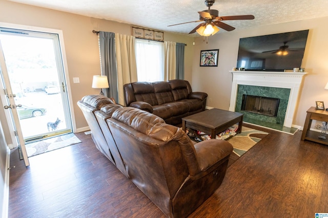 living room featuring dark hardwood / wood-style floors, a textured ceiling, and a fireplace